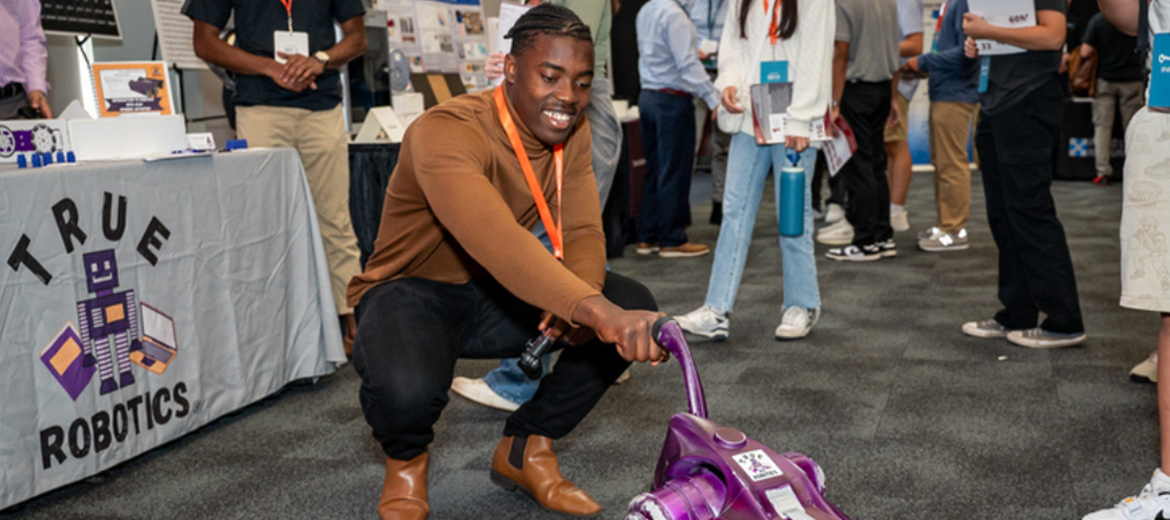 2024 Mash-Up student shaking hands with a robot